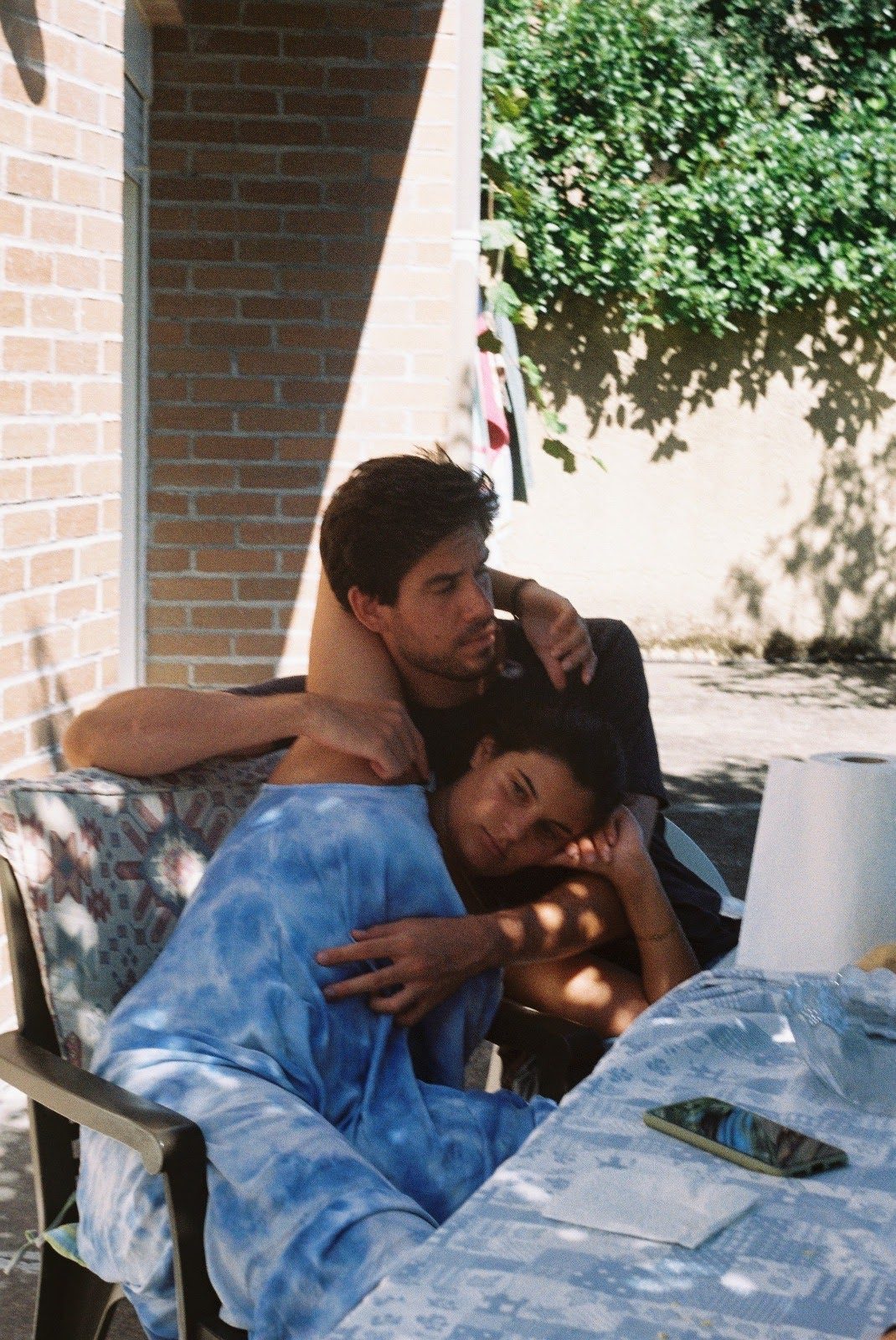 Joana and João resting together outdoors in warm summer light, on 35mm film.